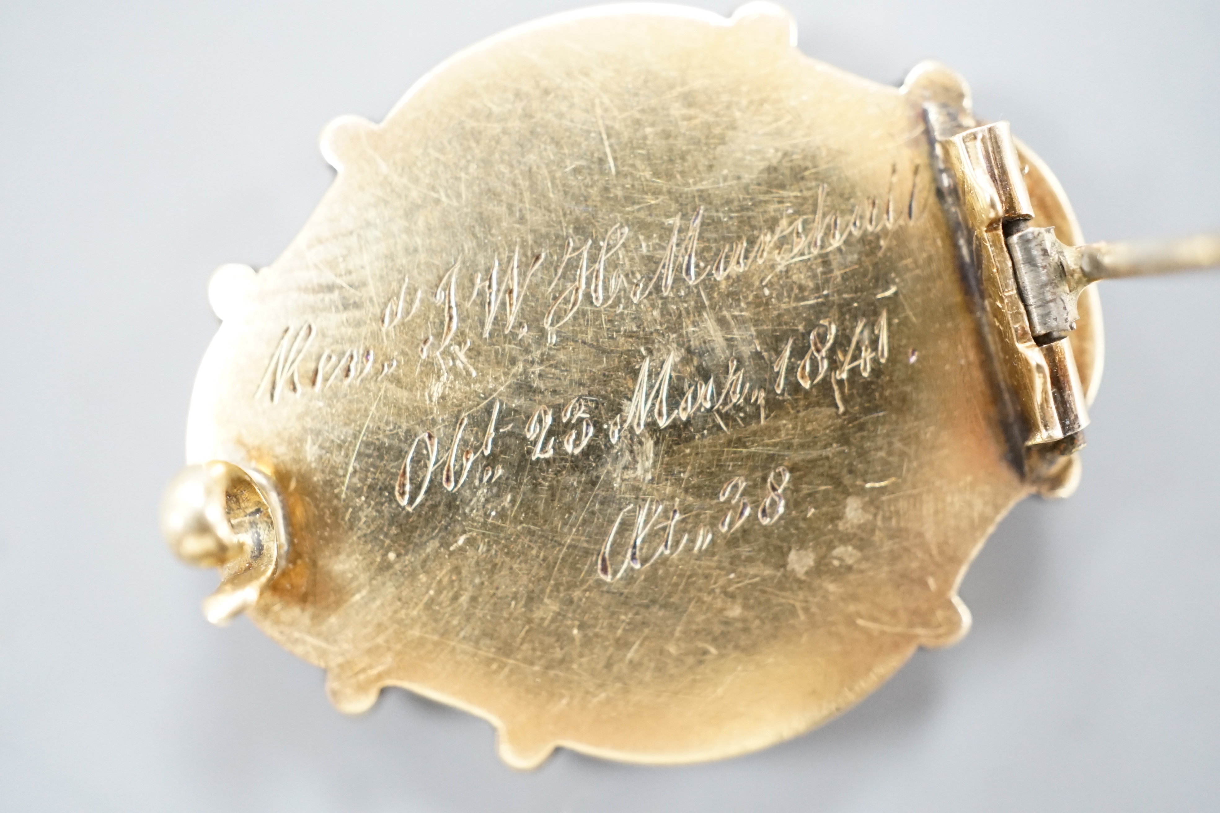 An early Victorian yellow metal, black enamel and plaited hair mourning brooch, inscribed verso, 'Revd. JWH Marshall Obt 23rd March, 1841 at 38', 27mm.
